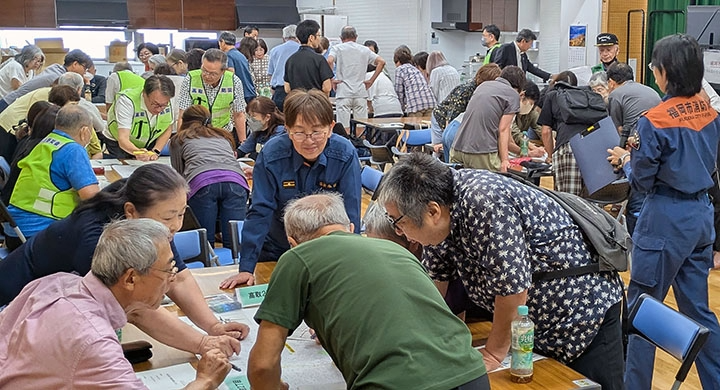 町内のブロックごとに地図へ書き込む図上訓練のようす